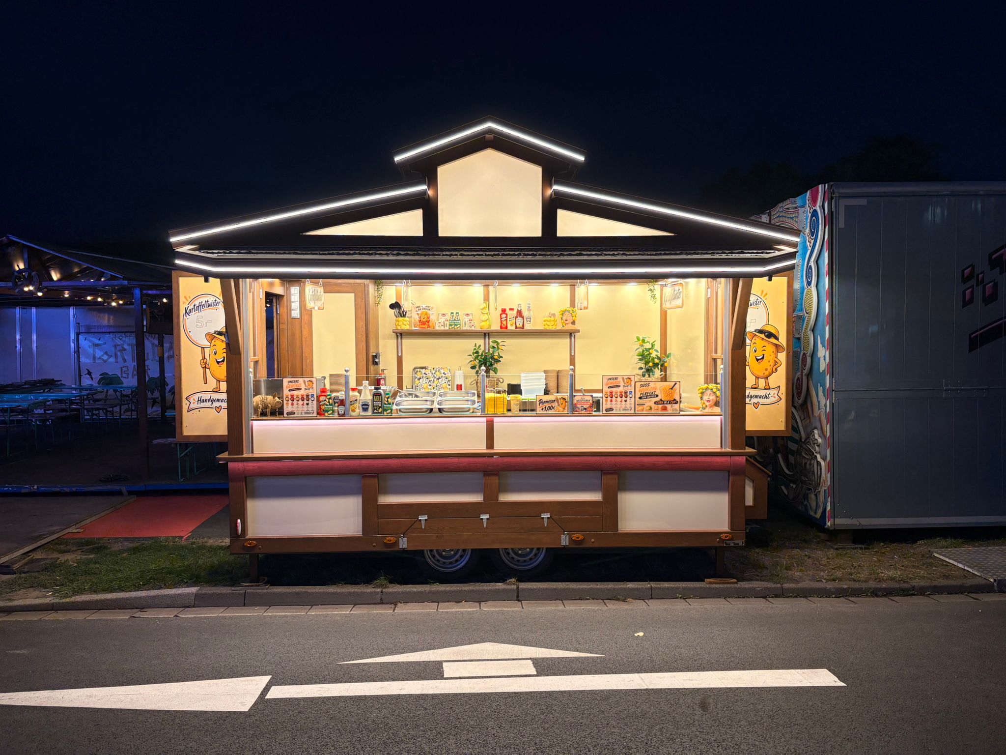 Beleuchteter Verkaufswagen bei Nacht auf dem Festplatz