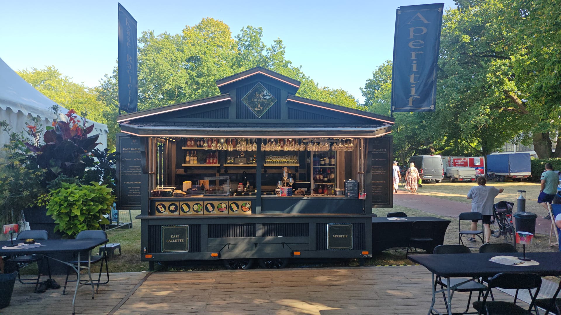 Hütte für Käse, Wein und Raclette mit Gästen im Park