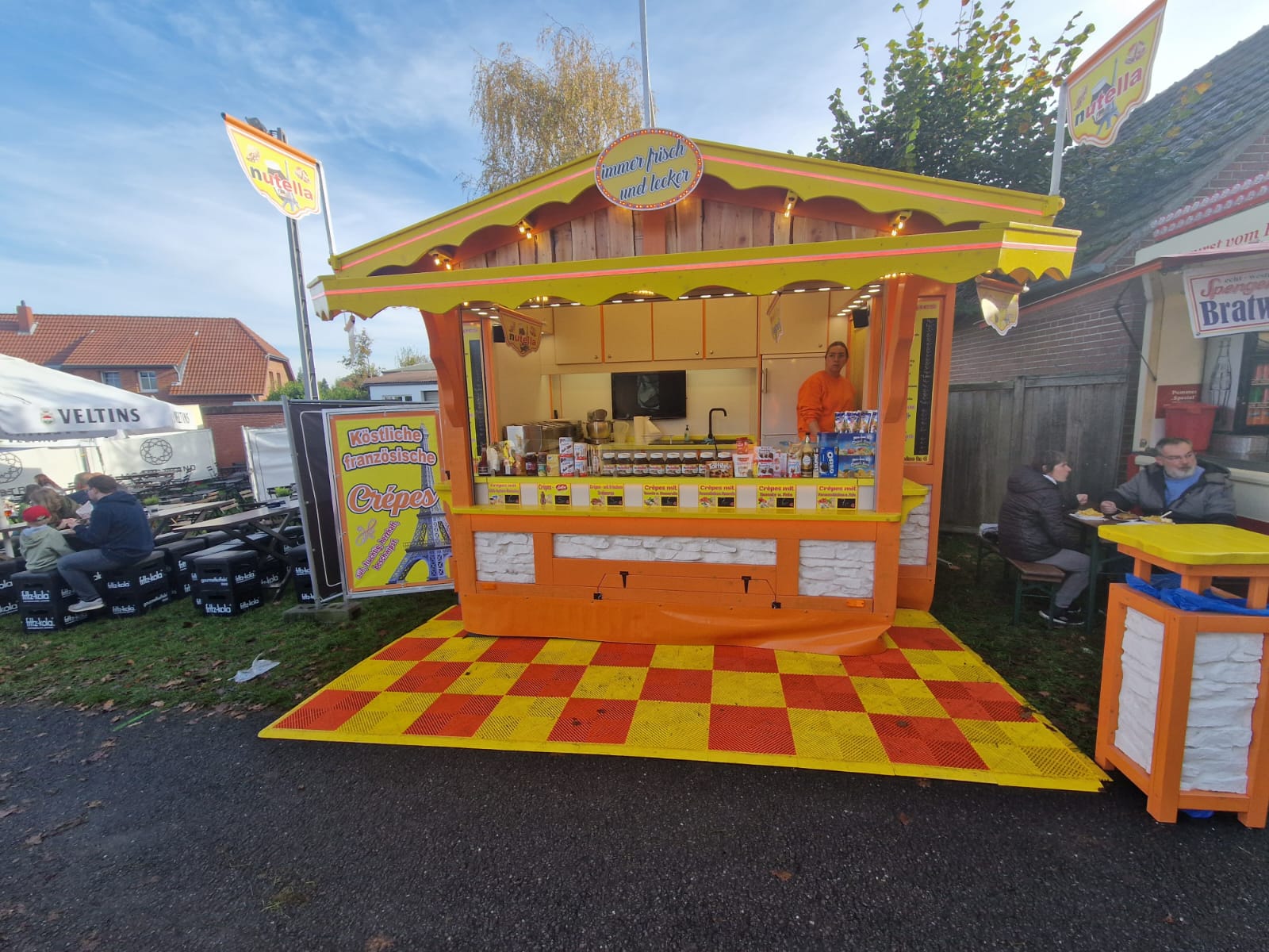 Crêpes-Hütte in Gelb und Orange mit Gästen